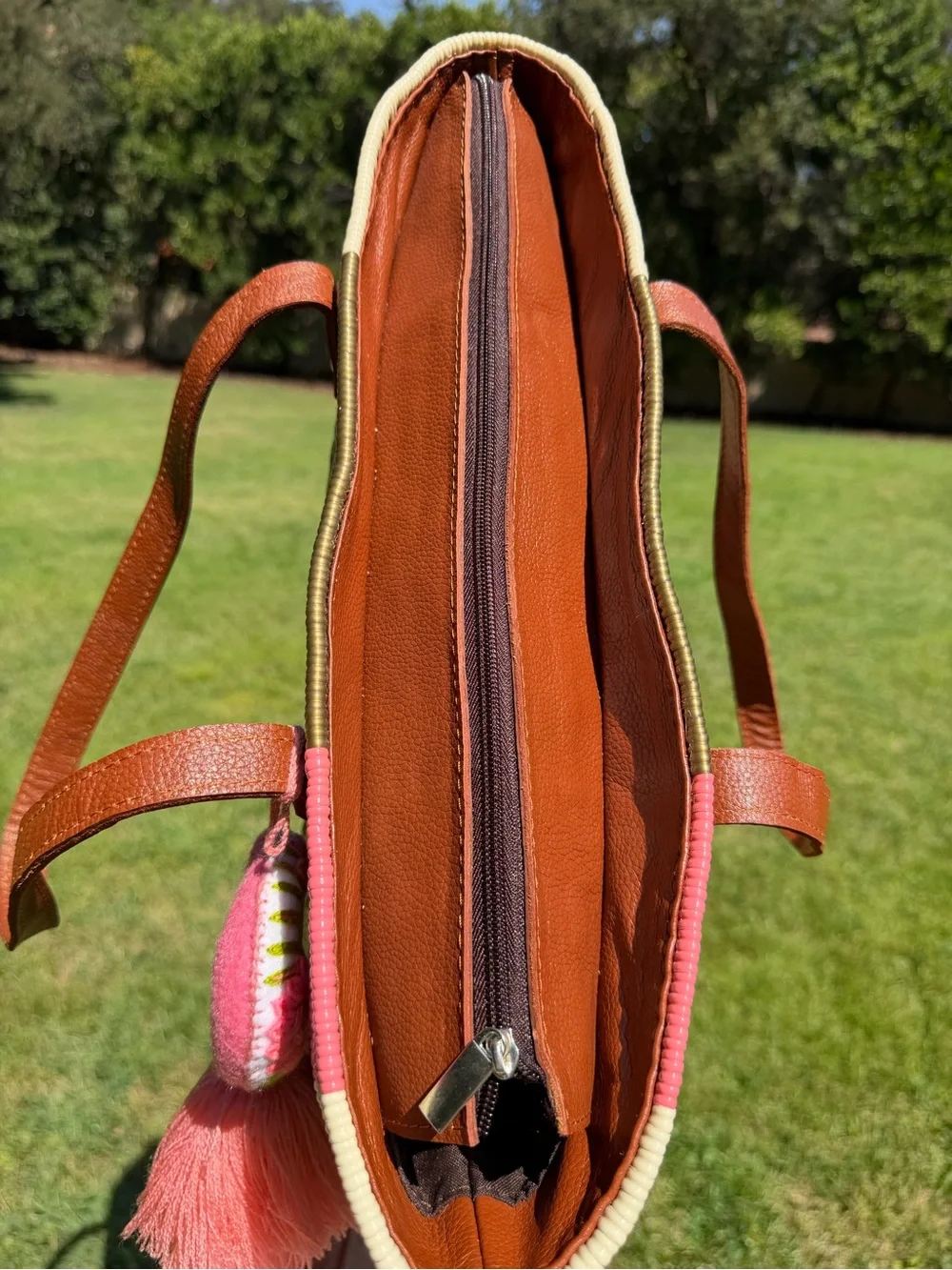 Woven Straw Tote Bag with Brown Leather Handles and Pink Tassel Accent